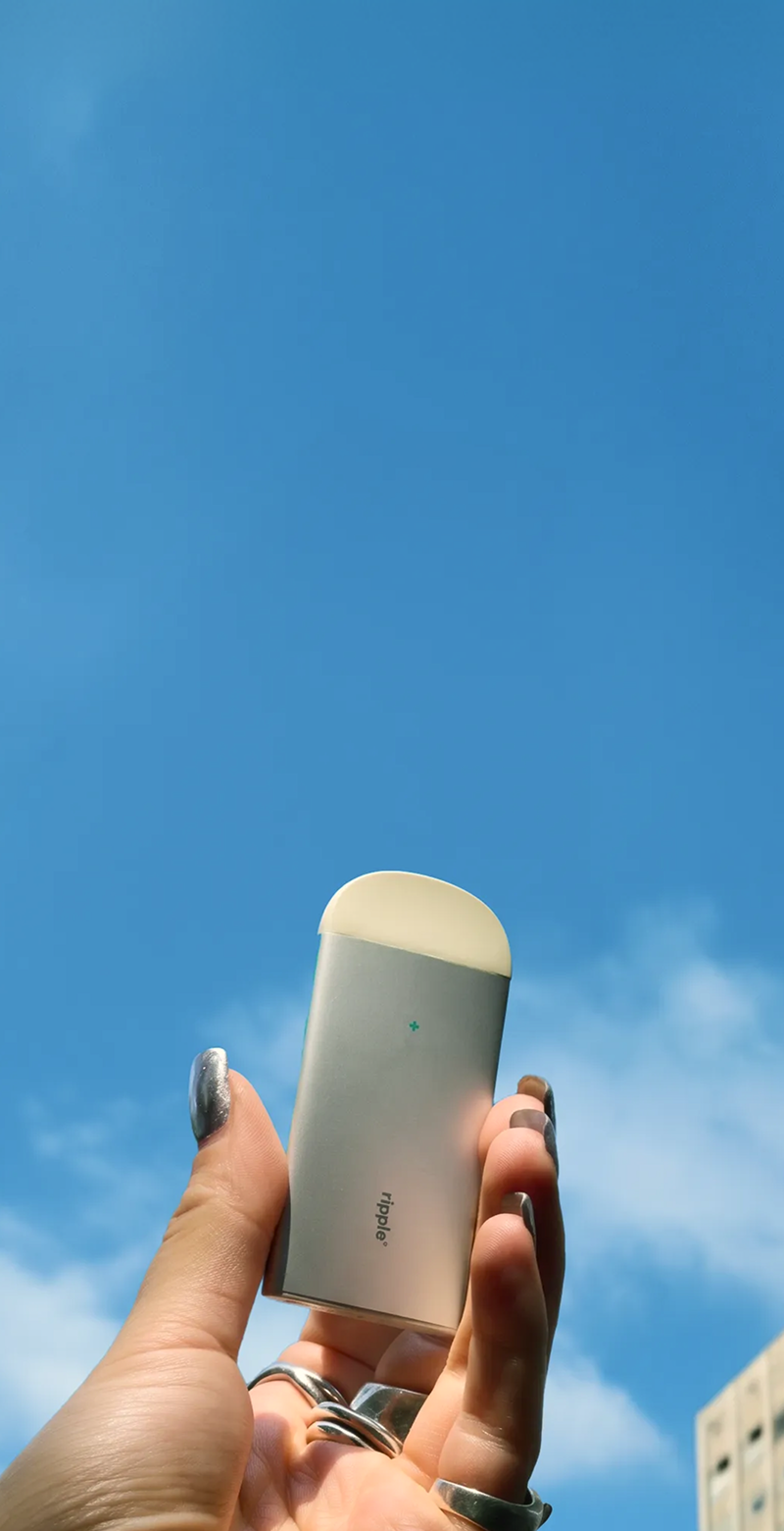 ripple+ air flavored air device held against a blue sky